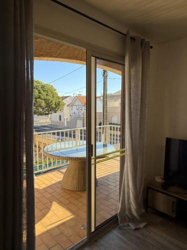 d'une porte coulissante en verre avec vue sur un balcon. dans l'établissement Valras-Loc - Appartement avec terrasse et parking,, à Valras-Plage