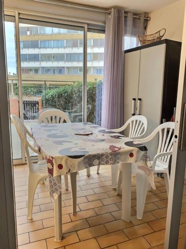 une salle à manger avec une table blanche et des chaises blanches dans l'établissement Appartement pour 4 personnes à 50m de la plage, à Valras-Plage