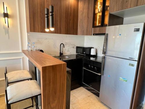 a kitchen with a stainless steel refrigerator and a counter at Dynasty Estate, Appartements avec Terrasse et vue sur Twin Center in Maarif
