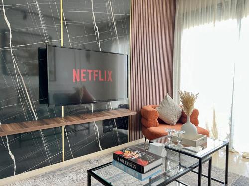 a living room with a television and a chair at Dynasty Estate, Appartements avec Terrasse et vue sur Twin Center in Maarif