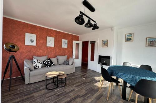 un salon avec un canapé et une table dans l'établissement Family apartment near the castle of Caen, à Caen
