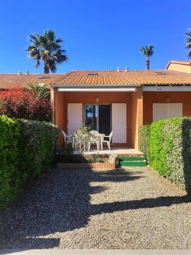 une maison avec une table et une chaise devant dans l'établissement Pavillon pour 4 personnes dans une résidence avec piscine, à Valras-Plage