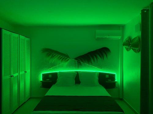 a green bedroom with a bed with a green light at L'Escapade - séjour romantique à Marie-Galante, calme, plage à deux minutes à pied in Grand-Bourg