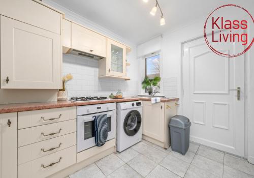 a kitchen with a washer and dryer next to a door at Bute Apartment by Klass Living Coatbridge in Coatbridge