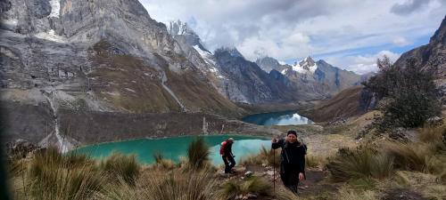 two people standing in front of a mountain lake at HUAYHUASH TREK HOTSPRINGS start and finish in hotsprings 10 days one night purchase valued in 10 days trekking in Huaraz