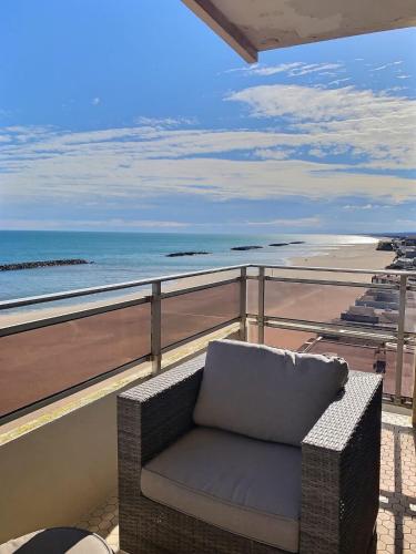 une chaise sur un balcon avec vue sur l'océan dans l'établissement Magnifique appartement avec vue mer panoramique !, à Valras-Plage