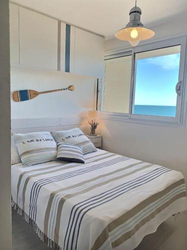 une chambre blanche avec un lit avec une fenêtre dans l'établissement Magnifique appartement avec vue mer panoramique !, à Valras-Plage