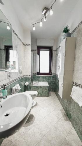 a bathroom with a tub and a toilet and a sink at Light Blue House in Montesilvano