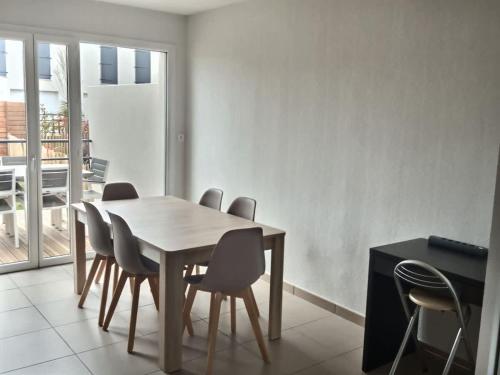 une salle à manger avec une table et des chaises en bois dans l'établissement A 500m de la plage, pavillon confortable 6 personnes dans résidence recente, à Valras-Plage