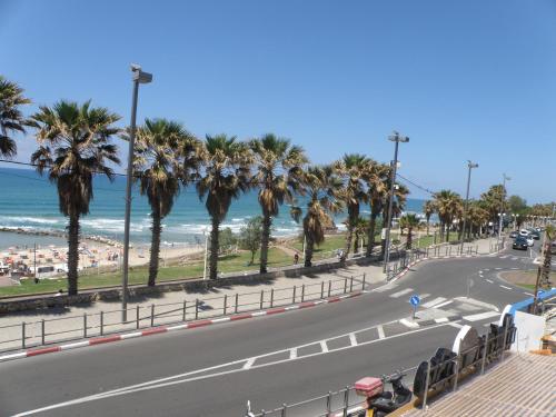 a street with palm trees and the beach at Spat Beach in Bat Yam