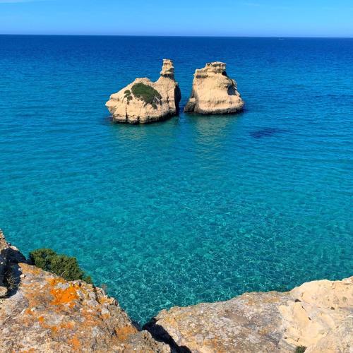 two large rocks in the ocean with blue water at Casa delle Zie in Lequile