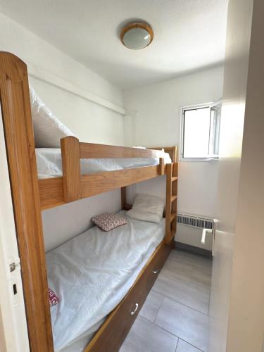 Cette petite chambre dispose de 2 lits superposés et d'une fenêtre. dans l'établissement Confort & terrasse a 650 m de la mer, à Valras-Plage