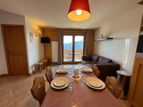 un salon avec une table, des chaises et un canapé dans l'établissement Appartement cosy 4 pers, proche pistes, tout équipé - FR-1-293-405, à Hauteluce