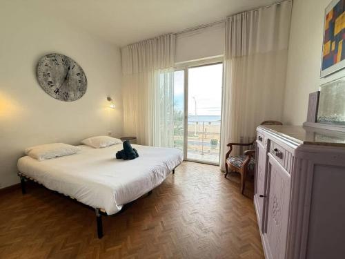 - une chambre dotée d'un lit avec une horloge murale dans l'établissement Valras-Loc -Bel appart 120m2, à Valras-Plage