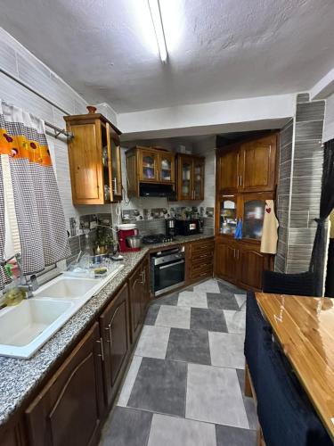 a kitchen with wooden cabinets and a checkered floor at Évasion Marine - Plage & Attractions à 5 Min in Mostaganem