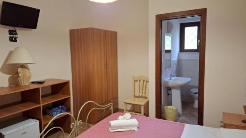 a room with a table and a bathroom with a sink at Capocanto Rooms in Camerota