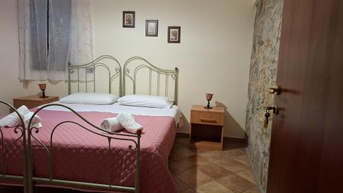 a bedroom with a bed with a pink blanket at Capocanto Rooms in Camerota