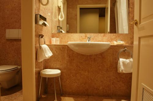 La salle de bains est pourvue d'un lavabo et de toilettes. dans l'établissement Pousada Palacio de Queluz, à Queluz