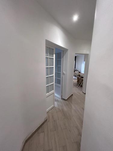 une pièce vide avec des murs blancs et du parquet dans l'établissement Appart tout confort, à Marseille