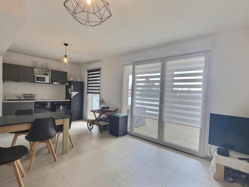 Il comprend un salon avec une table à manger et une cuisine. dans l'établissement Appartement climatisé, moderne avec terrasses à 500m de la mer, à Sérignan