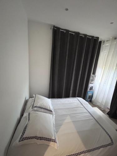 une chambre avec un lit et une fenêtre avec des rideaux dans l'établissement Appart tout confort, à Marseille