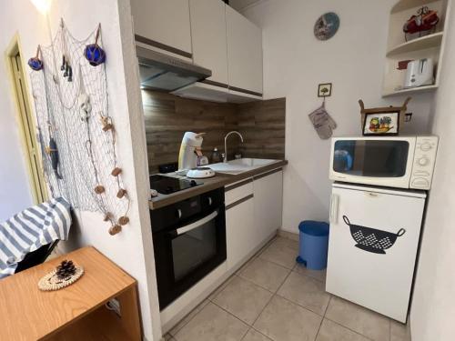 une petite cuisine avec un évier et une cuisinière dans l'établissement Appartement, à Valras-Plage