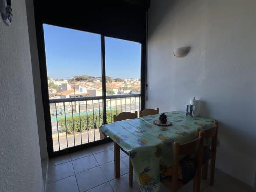une salle à manger avec une table et une grande fenêtre dans l'établissement Appartement, à Valras-Plage
