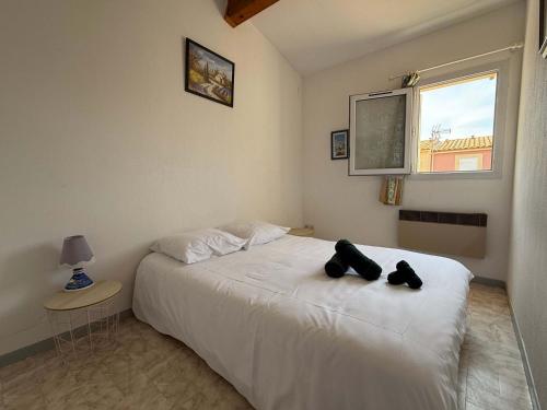 - une chambre dotée d'un lit avec deux ours en peluche noire dans l'établissement LES JARDINS DE LA MER -Coquet pavillon à deux pas de la plage, à Valras-Plage