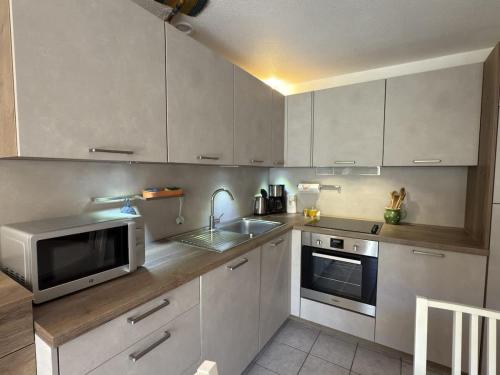 La cuisine est équipée d'un four micro-ondes et d'un évier. dans l'établissement A 200m de la plage Confortable pavillon pour 6 personnes, à Valras-Plage