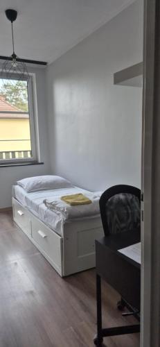 a bedroom with a bed and a chair and a window at Mieszkanie Borneo in Borne Sulinowo