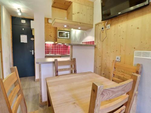 une cuisine et une salle à manger avec une table et des chaises en bois dans l'établissement Charmant studio divisible skis aux pieds, 4 pers, proche commerces et remontées, animaux admis - FR-1-182-198, à Les Allues