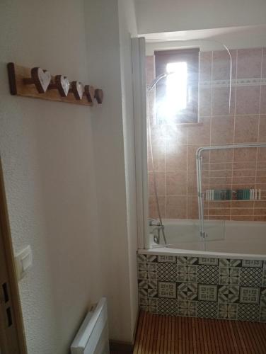 une salle de bain avec une baignoire et une fenêtre dans l'établissement Appartement les longes, à Saint-François-Longchamp