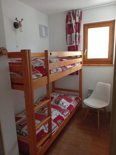 - une chambre avec 2 lits superposés et une chaise dans l'établissement Appartement les longes, à Saint-François-Longchamp