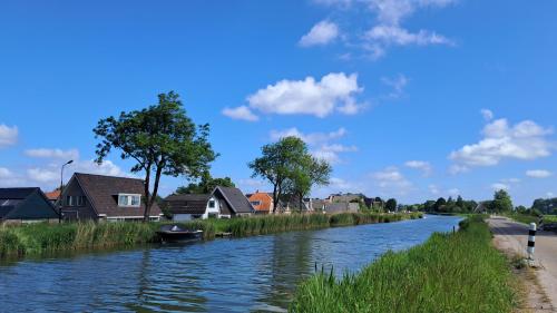 a river with houses on the side of it at De Rozenbottel met privé sanitair in Hensbroek