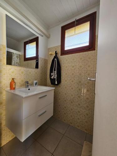 une salle de bain avec un lavabo blanc et une douche dans l'établissement Valras-Loc - Studio avec terrasse et exterieur, à Valras-Plage