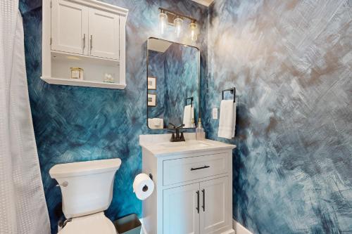 a bathroom with a toilet and a sink and a mirror at Front Porch Looking In in Black Mountain