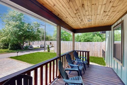 a porch with chairs and a wooden ceiling at Front Porch Looking In in Black Mountain