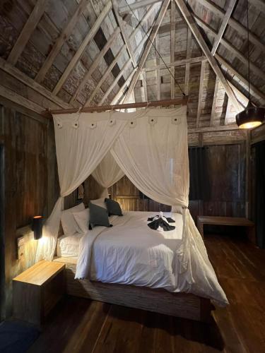 a bedroom with a bed with a mosquito net at Pondok Satu Hati Sidemen in Sidemen