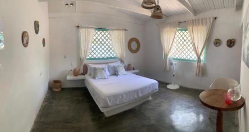 a bedroom with a white bed and two windows at Isla Tijereto in Isla Grande