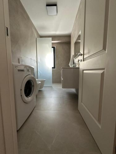 a bathroom with a washing machine and a sink at Aurela Apartment in Lezhë