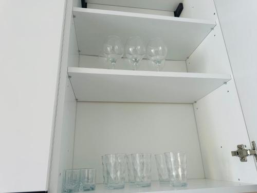 a row of wine glasses sitting on a shelf at Aurela Apartment in Lezhë