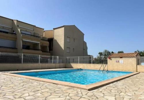 une grande piscine devant un immeuble dans l'établissement Appartement Marseillan-Plage, à Marseillan