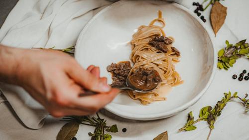 a person is eating a plate of pasta at Lahnerhof Chalets in Lutago