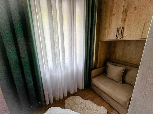 a small room with a window and a couch at Fryma e Bjeshkeve in Theth