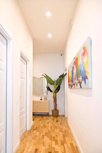 a hallway with a painting on the wall and a plant at RELAIS DELL'USSERO Pisa centro in Pisa