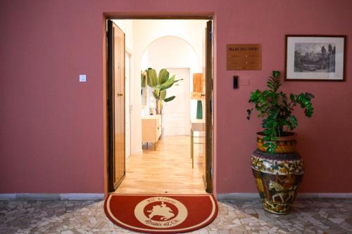 a hallway with a mirror and a large vase at RELAIS DELL'USSERO Pisa centro in Pisa