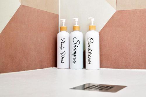 three white bottles sitting on top of a counter at RELAIS DELL'USSERO Pisa centro in Pisa