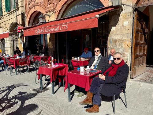 a group of people sitting at tables outside a restaurant at RELAIS DELL'USSERO Pisa centro in Pisa