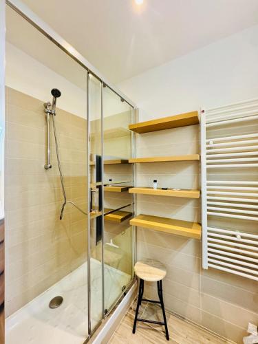 La salle de bains est pourvue d'une cabine de douche avec un tabouret. dans l'établissement L'impérial - Apt 3 Prs vue mer - Clim - Parking, à Vallauris