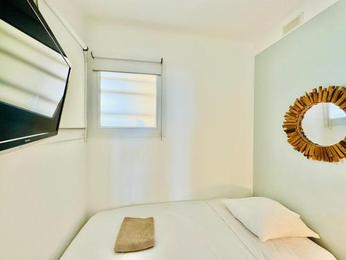 une chambre avec un lit avec un miroir et une fenêtre dans l'établissement L'impérial - Apt 3 Prs vue mer - Clim - Parking, à Vallauris